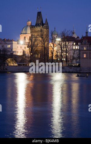 Lo stile gotico città vecchia torre sul Ponte Carlo a Praga con la barocca chiesa di notte illuminazione. Vista d'inverno. Foto Stock