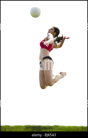 Donna di salto e spiking pallavolo esterni Foto Stock