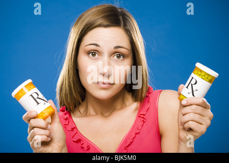 Donna che mantiene due bottiglie di capsule di prescrizione Foto Stock