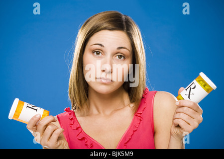 Donna che mantiene due bottiglie di capsule di prescrizione Foto Stock