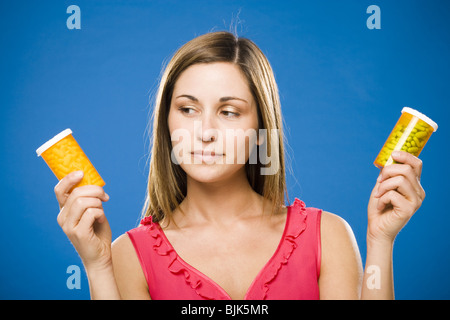 Donna che mantiene due bottiglie di capsule di prescrizione Foto Stock