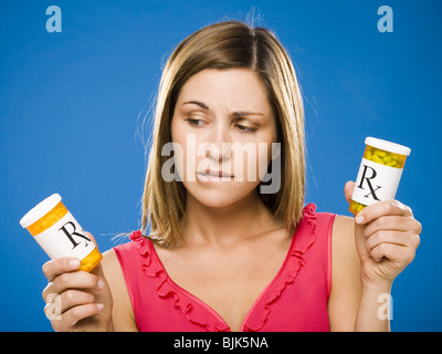 Donna che mantiene due bottiglie di capsule di prescrizione Foto Stock