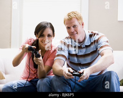 L uomo e la donna sul divano per giocare con i videogiochi Foto Stock