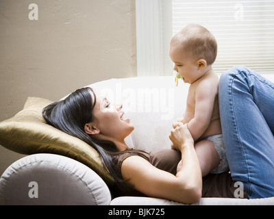 Donna sdraiata sul divano con il bambino Foto Stock