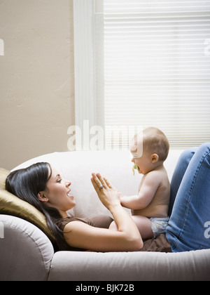 Donna sdraiata sul divano con il bambino Foto Stock