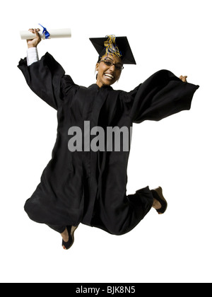 Donna in abito di graduazione e segno bianco con diploma jumping Foto Stock