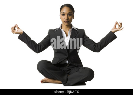 Imprenditrice seduta zampe trasversale fare yoga Foto Stock