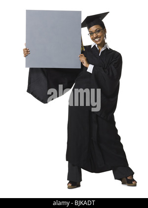 Donna in abito di graduazione e segno bianco con segno vuoto Foto Stock