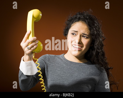 Donna che mantiene telefono retrò e urlare Foto Stock