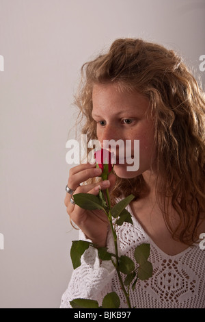 Donna odorare una rosa Foto Stock