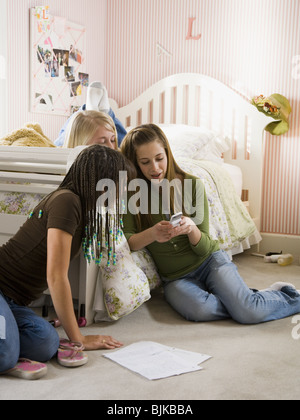 Tre ragazze in camera da letto con lettore mp3 Foto Stock