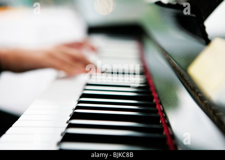 Le mani su una tastiera di pianoforte Foto Stock