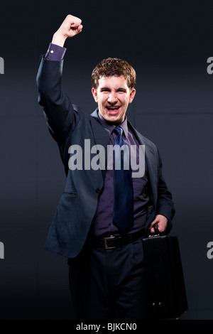 Uomo d affari con valigetta e il braccio fino a sorridere Foto Stock