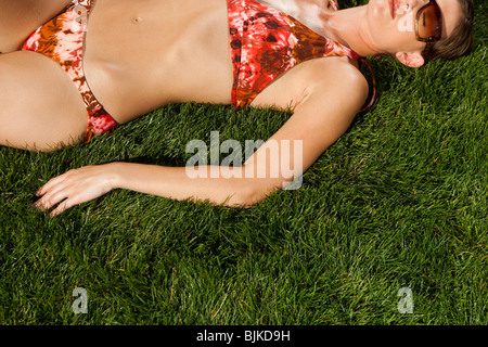 La donna a prendere il sole sul prato Foto Stock