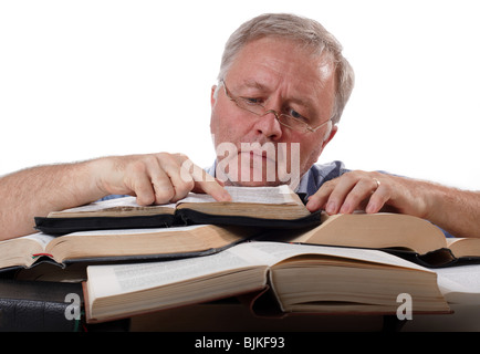 Uomo con occhiali lavora con molti libri Foto Stock