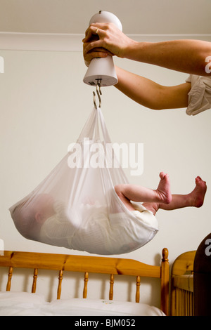 La pesatura di un neonato / new born baby con scale / peso scala. Foto Stock