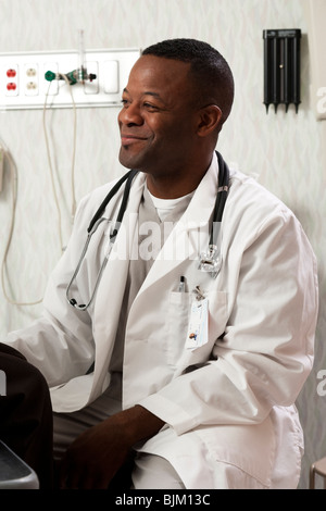 Donna che parla al medico nella sala esame Foto Stock