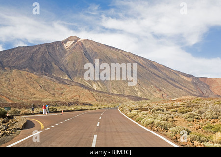 Una strada corre sotto i 3718 metri di un alto monte Teide nel Parco Nazionale del Teide sull'isola di Tenerife, Spagna. Foto Stock