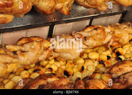 Un commerciale su larga scala di pollo intero e patate arrosto rotisserie. Foto Stock