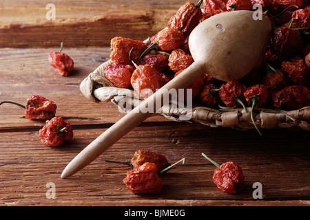 Mini-Peppers (capsicum) in un cesto di vimini su un rustico sfondo di legno Foto Stock