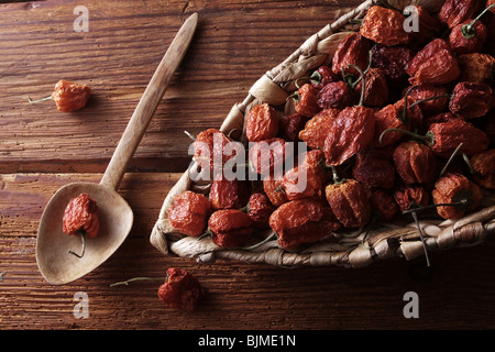 Mini-Peppers (capsicum) in un cesto di vimini su un rustico sfondo di legno Foto Stock