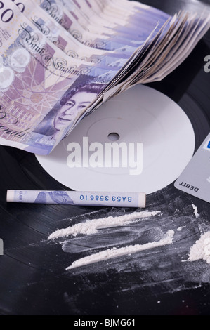 Una foto che mostra il consumo di cocaina nel settore della musica con linee di polvere bianca su una etichetta bianca e record di contanti nel Regno Unito Foto Stock