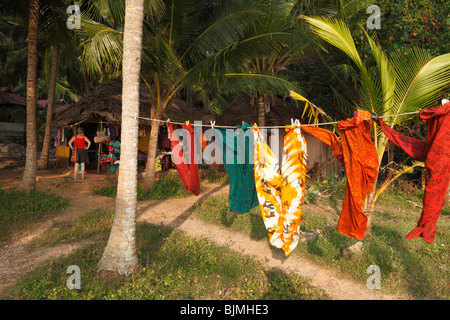 Tessuti appesi su uno stendibiancheria, cucitura hut sotto le palme, a sud di Kovalam, Kerala, India, Asia Foto Stock