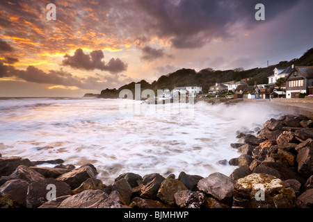 Impostazione di Sun sulle onde che si infrangono sulle rocce a Steephill Cove. Isola di Wight, England, Regno Unito Foto Stock