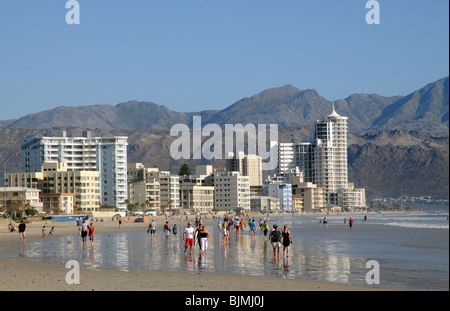 I villeggianti di camminare sulla spiaggia della località balneare denominato Strand in Western Cape Sud Africa Foto Stock