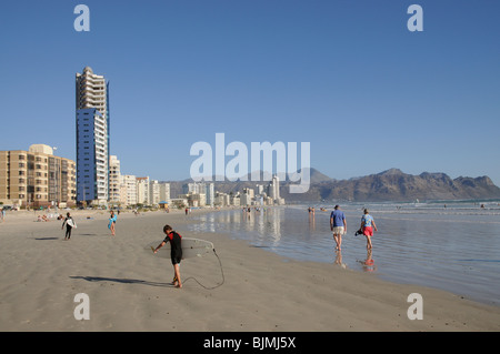 I villeggianti di camminare sulla spiaggia della località balneare denominato Strand in Western Cape Sud Africa Foto Stock