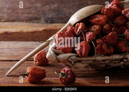 Mini-Peppers (capsicum) in un cesto di vimini su un rustico sfondo di legno Foto Stock