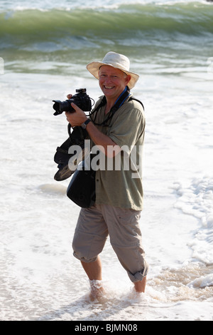 Fotografo con la fotocamera in acqua sulla spiaggia, Malabarian Costa, il Malabar, Kerala, India, Asia Foto Stock