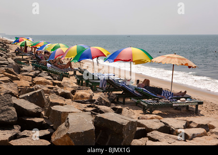 India Kerala, Vypeen Isola, Cherai Beach Resort, gli ospiti rilassarsi sui lettini sotto colouful ombrelloni Foto Stock