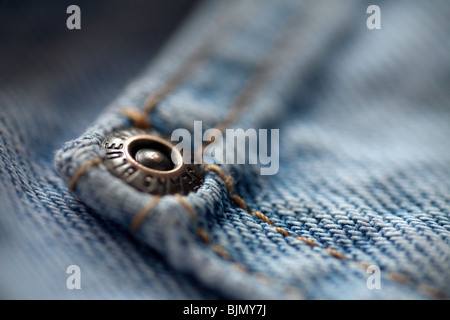 Dettaglio di uno dei perni di metallo sul "denaro in tasca' della coppia di sbiadito blu jeans denim. Foto Stock