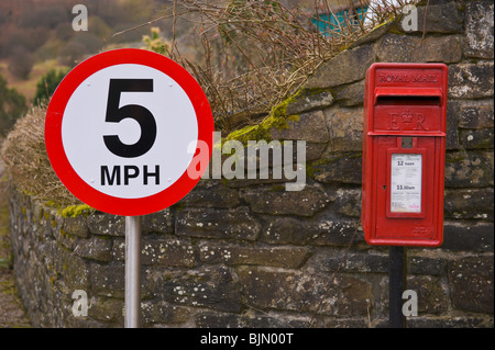 Postbox rosso e 5 mph velocità segno di avvertimento a Elizabeth fila vicino Talywain Lancaster South Wales UK Foto Stock