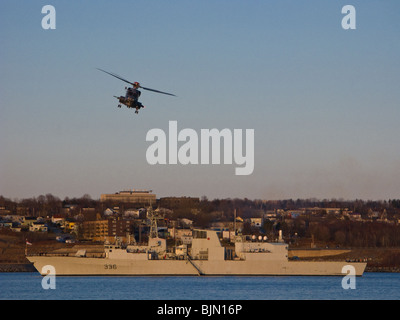 Un banco di prova Sikorsky CH-148 pratiche ciclone atterraggi sulla marina canadese fregata HMCS MONTREAL (FFH 336) nel porto di Halifax. Foto Stock