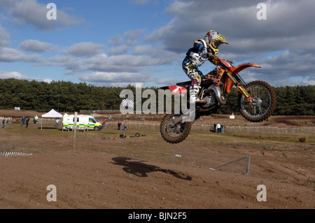 Motociclista volare in aria in alto sulla sua moto motocross Foto Stock