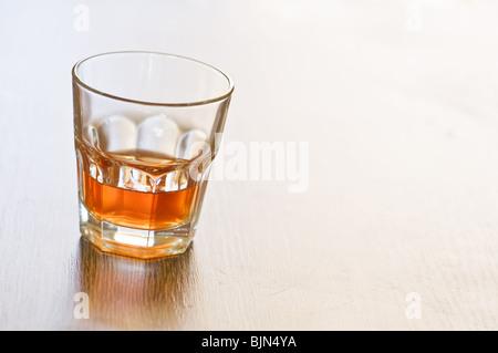 Bicchiere di whiskey sul contatore di legno Foto Stock