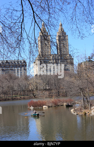 Rowboating sul lago nella città di New York, in zona Central Park, con la San Remo appartamento edificio su Central Park West in background. Foto Stock