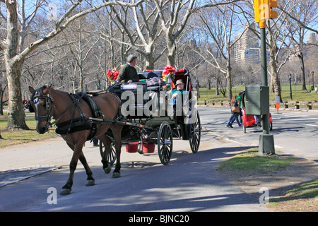 Un giro in un carro trainato da cavalli hansom cab Central Park di New York City Foto Stock