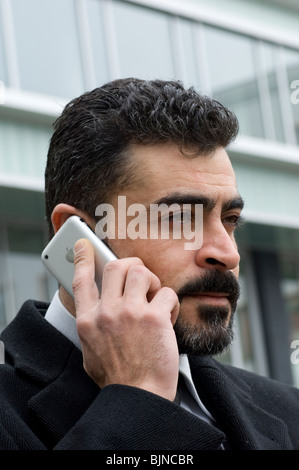 Business man parlando su un Iphone mobile al di fuori di un edificio per uffici a Berlino Germania Foto Stock