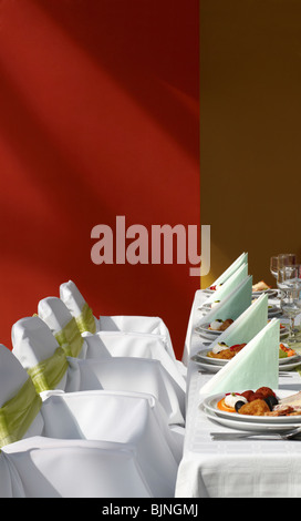 La disposizione dei tavoli con sedie decorate e cena Foto Stock
