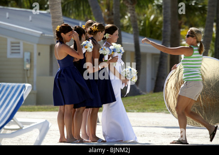 Fotografi aiuto assistente sposa e le sue damigelle hanno pronti per foto di matrimonio sulla spiaggia in Florida Keys su Islamorada Foto Stock