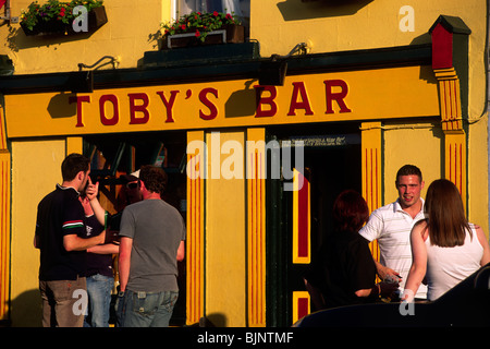 Irlanda, Contea di Mayo, Westport, gente che parla davanti al Toby's bar Foto Stock