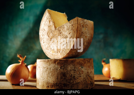 Taglio intero panno legato truckle rotondo di inglese agriturismo il formaggio cheddar in una impostazione Foto Stock