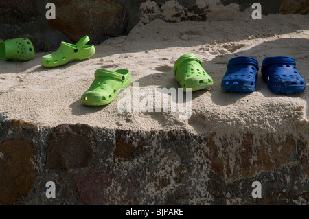 Scarpe di gomma sinistra sulla spiaggia Foto Stock