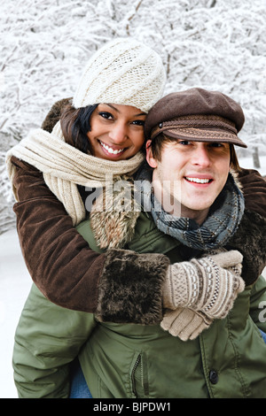 Ritratto di giovane avente piggyback ride all aperto in inverno Foto Stock