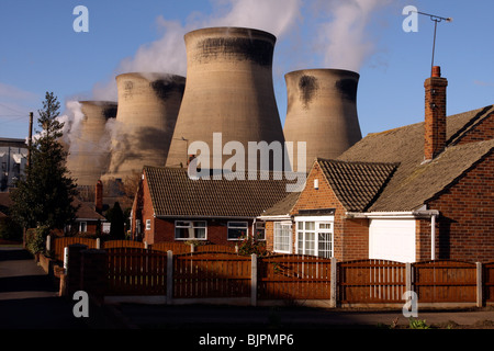 Gigante di torri di raffreddamento che domina lo skyline e le case vicine. Ferrybridge power station,Ferrybridge, nello Yorkshire, Regno Unito Foto Stock
