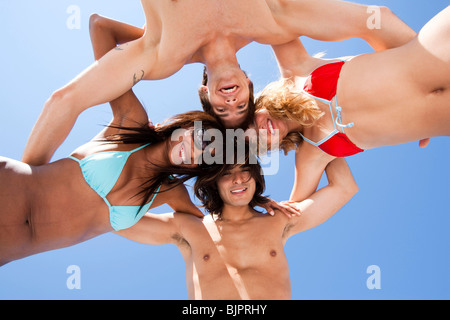 Quattro adulti in un gruppo huddle Foto Stock