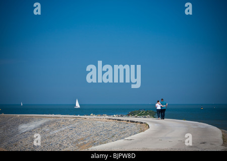 Giovane adulto giovane camminando lungo il mare Foto Stock